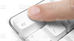 Forefinger pressing the ""escape"" button on a white keyboard.