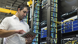 IT technician working on network servers and cables.